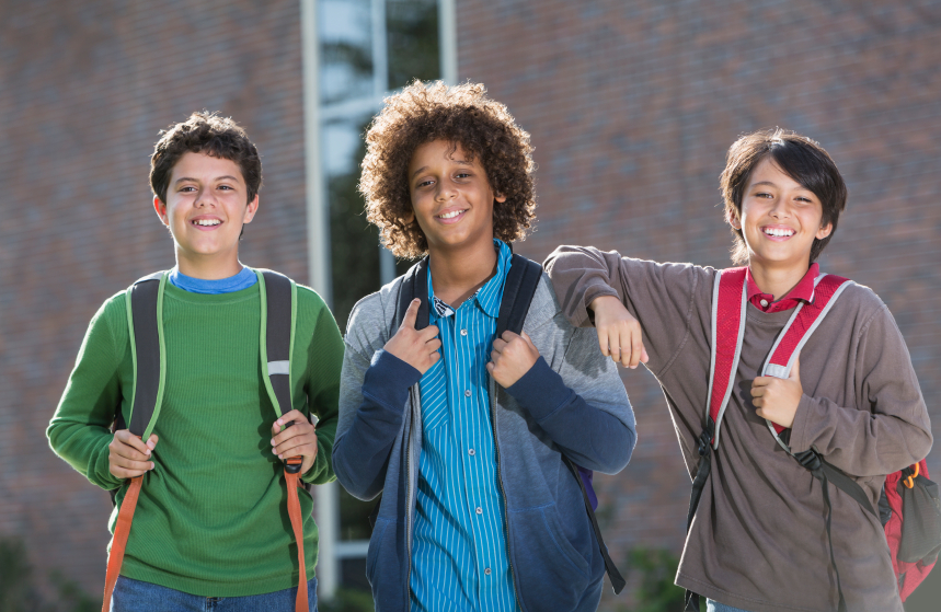 Boys standing outside school with backpacks